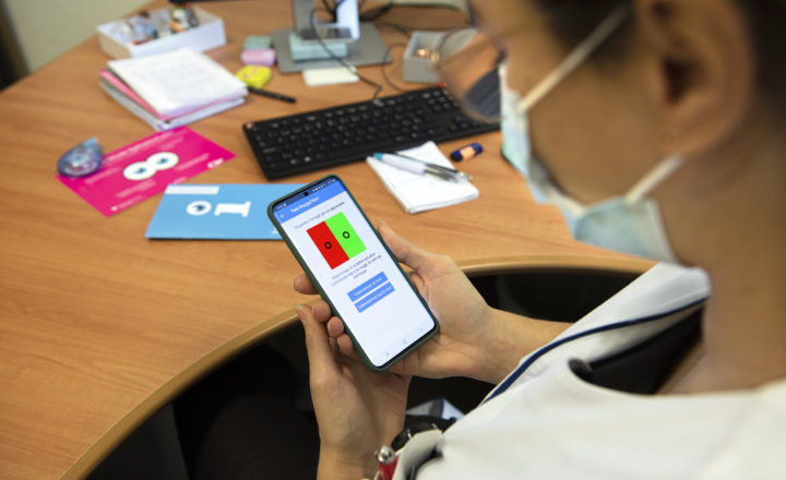 Personne utilisant l'application Infovision sur son smartphone.