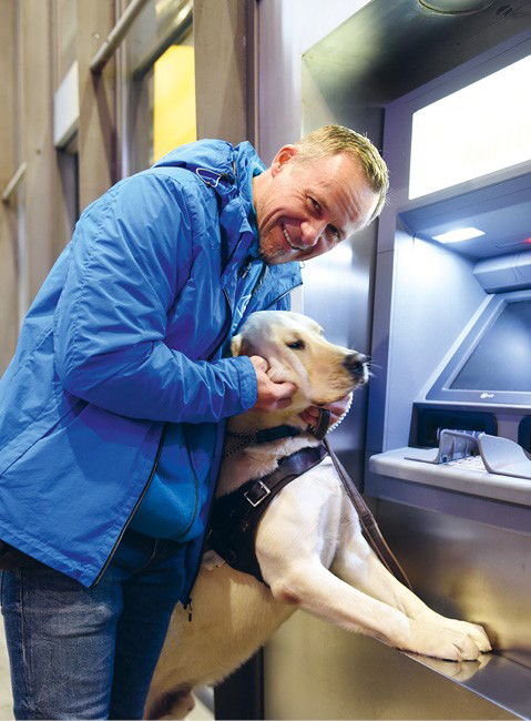 Fino, chien guide qui accompagne son maître au bancomat