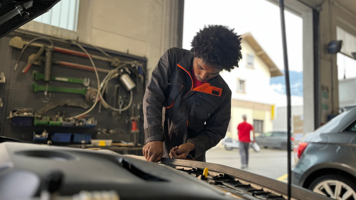 Adhanom, jeune carrossier malvoyant, en train de réparer une voiture.