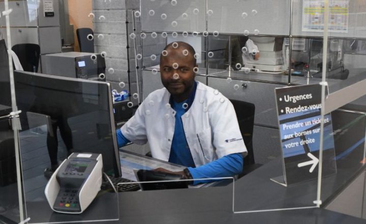 Un collaborateur à l'accueil de l'Hôpital ophtalmique. Il est le premier contact du patient avec l'un des métiers administratifs de la santé.