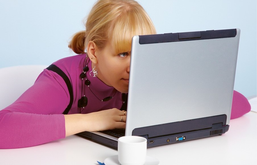 Photo d'une femme regardant son ordinateur de trop près au travail