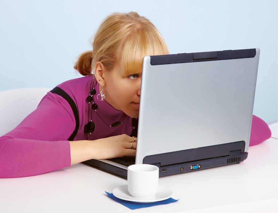 Photo d'une femme regardant son ordinateur de trop près au travail