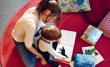 Image d'un enfant qui regarde avec sa maman un livre accessible pour les enfants malvoyants pour l'article "Être solidaire"
