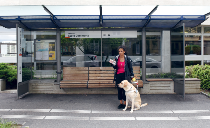 Rania, personne aveugle, avec son chien guide à l'arrêt de bus