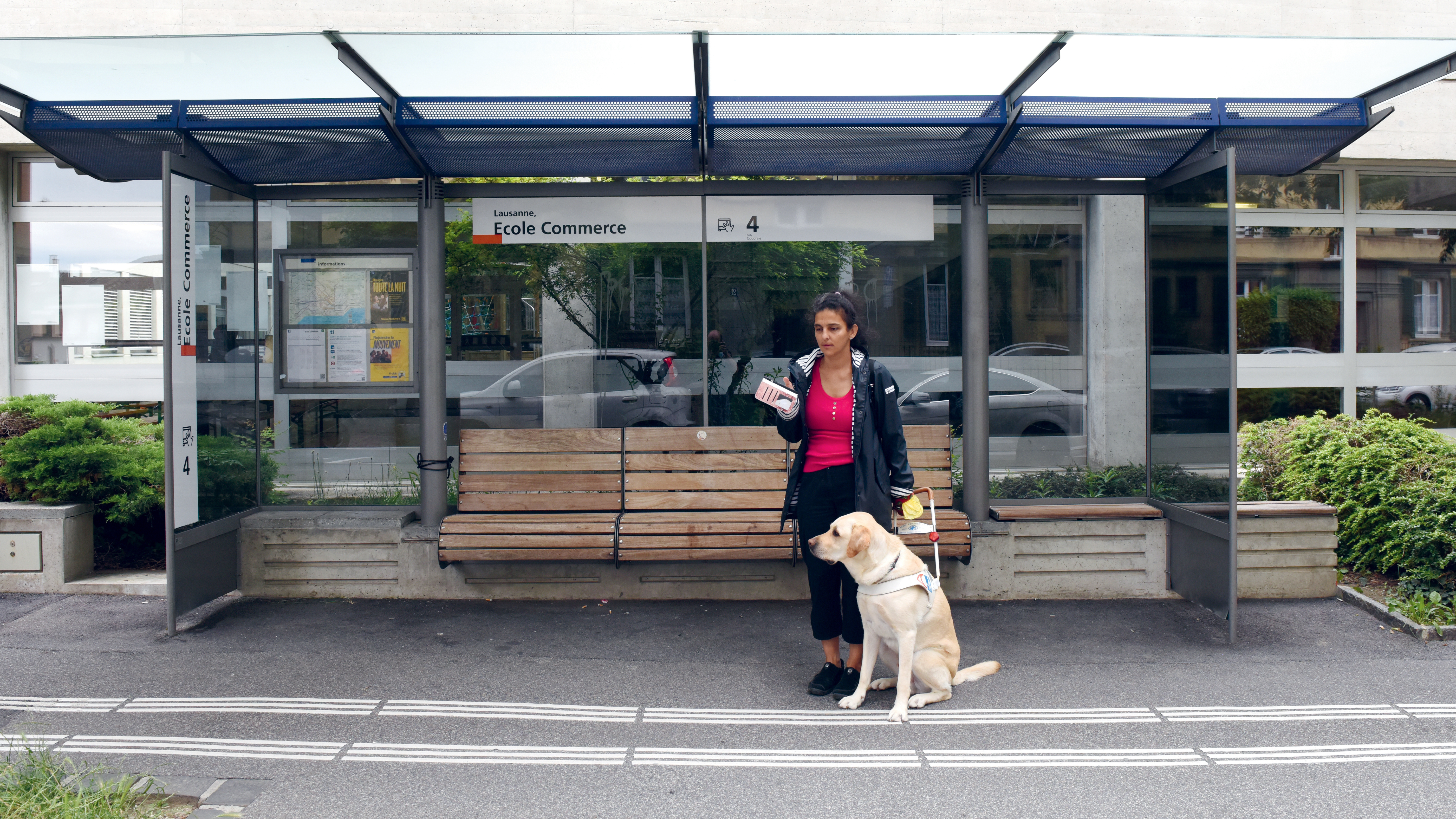 Rania, personne aveugle, avec son chien guide à l'arrêt de bus