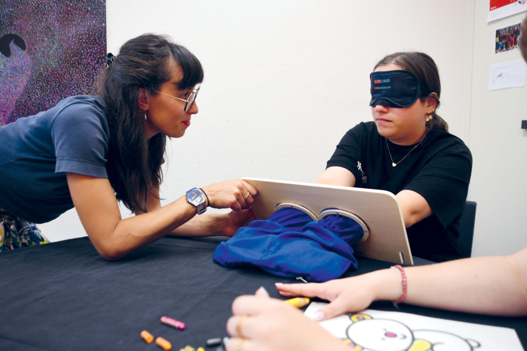 Les éducateurs et éducatrices se mettent à place des enfants malvoyants à l'aide des bandeaux et lunettes qui simulent une déficience visuelle.