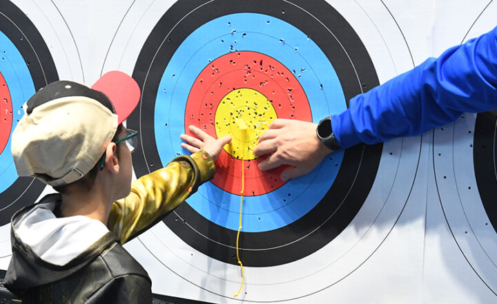 Photo d'un enfant malvoyant à une session de tir à l'arc