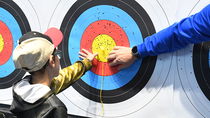 Photo d'un enfant malvoyant à une session de tir à l'arc