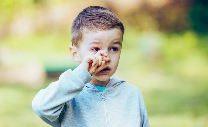 Photo d'un enfant qui se gratte les yeux à cause des allergies.