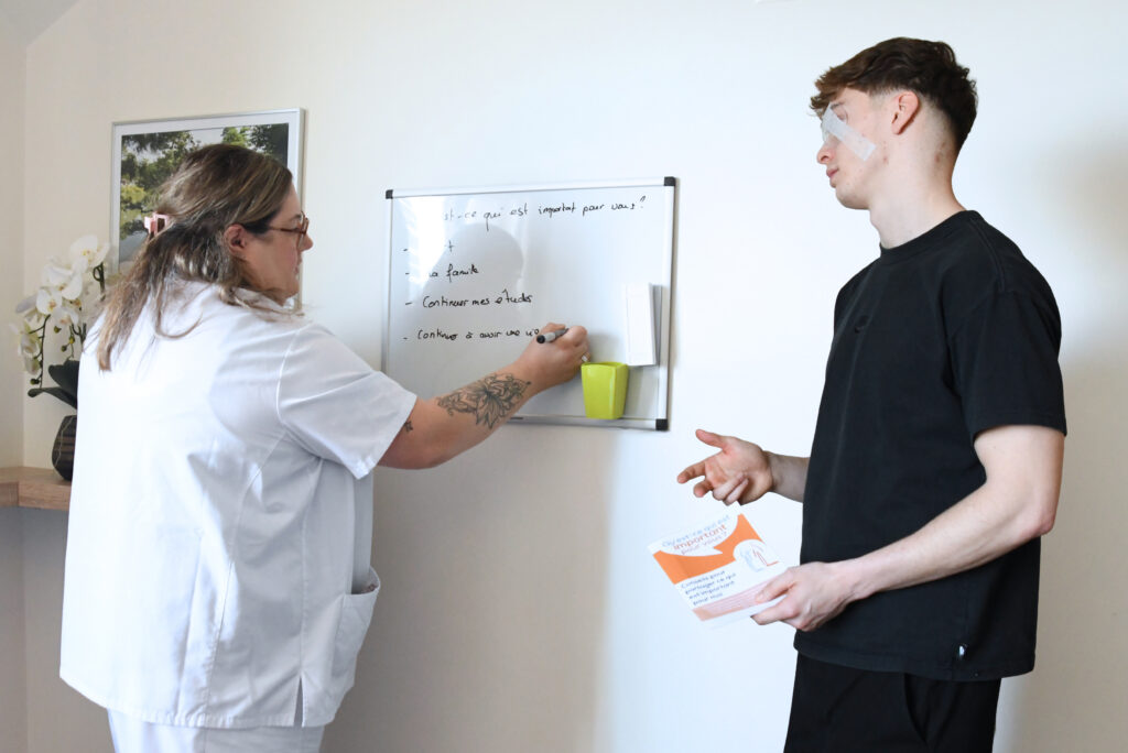 L'infirmière note sur le tableau les choses qui sont importantes pour le patient. 