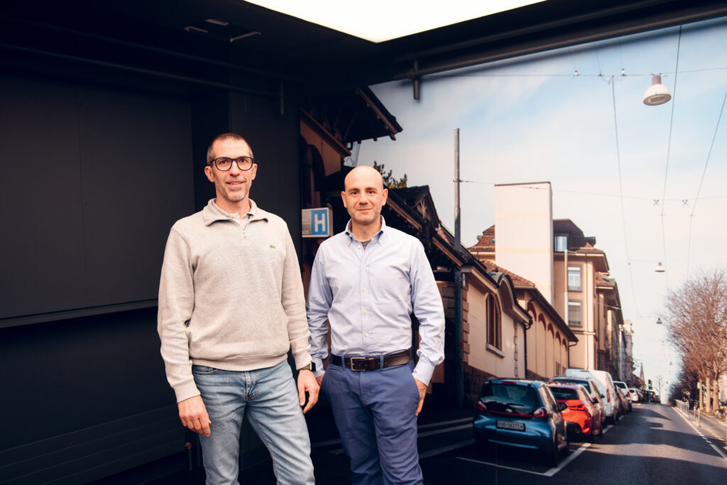 Dr Diego Ghezzi, PhD et Prof. Silvio Ionta 
devant un panneau du Mobility Lab repro
duisant l’avenue de France