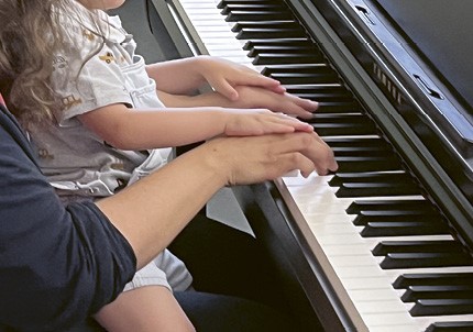 Quand il pose ses mains sur celles de la pianiste, l'enfant oublie tout du contexte hospitalier et se concentre sur la musique.