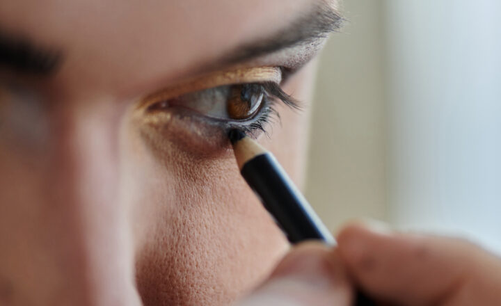 Photo d'une femme qui applique du maquillage autour de ses yeux.
