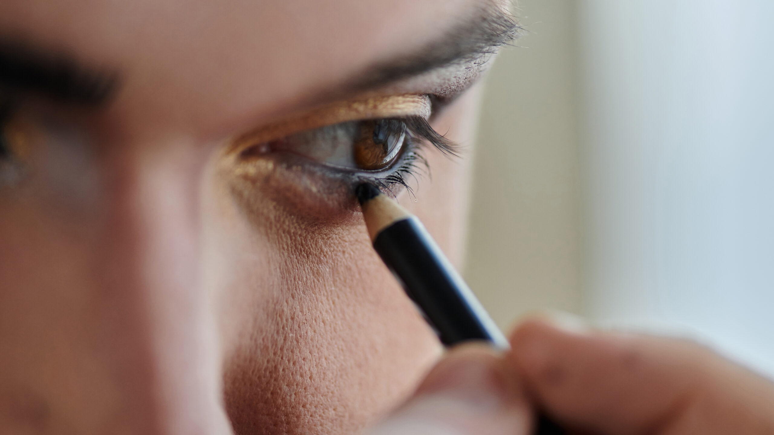 Photo d'une femme qui applique du maquillage autour de ses yeux.
